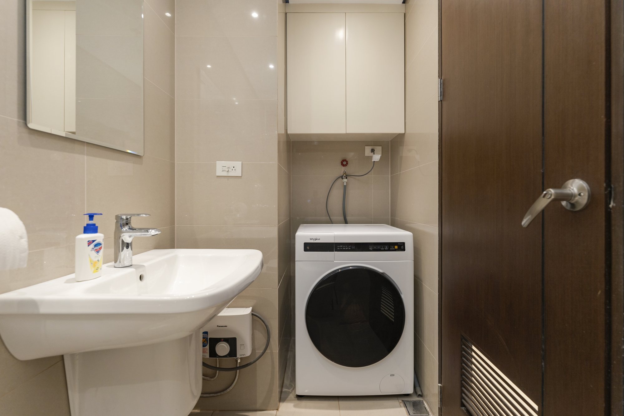 A washing machine beside the sink in the bathroom of the Amber Room condo in Cebu