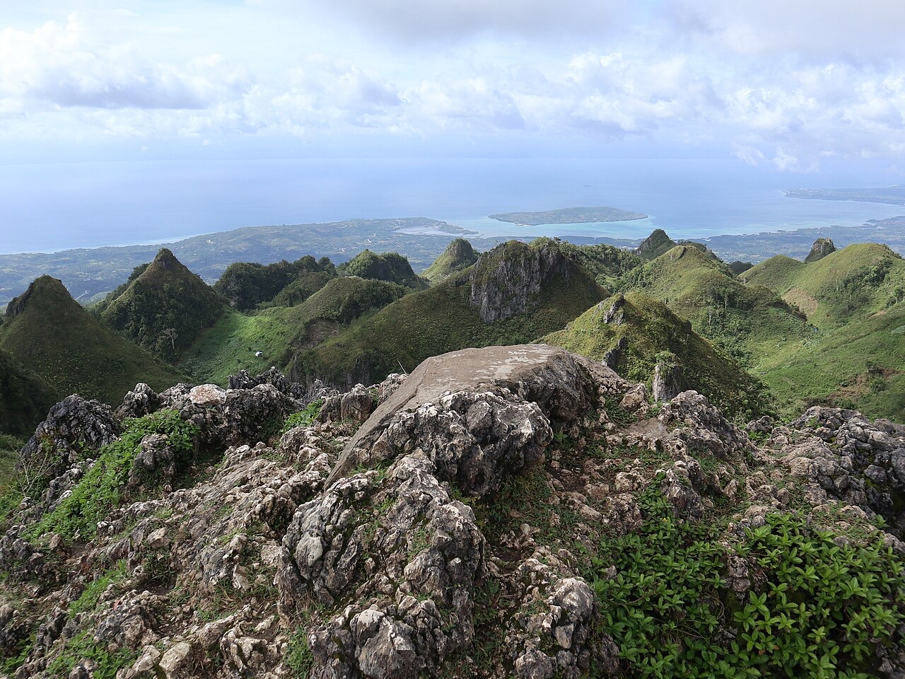 The rocky summit of Osmeña Peak in Dalaguete, with green hills rolling down to the sea